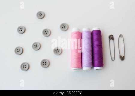 Nähset mit bunten Fadenspulen, Kunststoffknöpfen und Stiften. Ideal für Bastelinhalte, Schneiderei, heimwerkermode, handgemachte und kreative Hobbyarbeit. Stockfoto