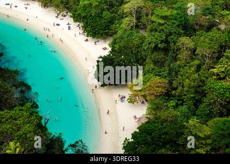 Besucher genießen die Schönheit von Koh Hong Island Thailand, während sie sich auf dem weichen weißen Sand, umgeben von üppigem Grün, entspannen. Das türkisfarbene Wasser weckt Stockfoto