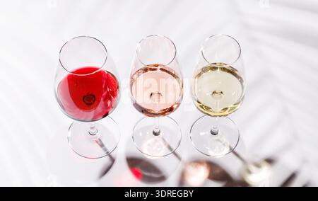 Drei Weingläser gefüllt mit Rot-, weiß- und Rosenwein Stockfoto