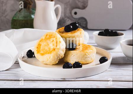 Süße Hüttenkäse Pfannkuchen und Beeren auf einem Teller auf dem Tisch Stockfoto