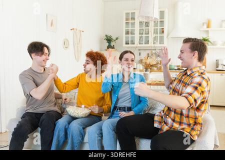 Eine Gruppe von Freunden, die sich ein Fußballspiel im fernsehen anschauen. Glückliche Fußballfans feiern zu Hause den Sieg. Freundschaft sp Stockfoto