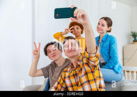 Applaus Funky-Stimmung. Glückliche Freunde machen Selfie. Ein Mann, der Freunde auf der Party fotografiert. Gruppe multirassischer Jugendlicher t Stockfoto