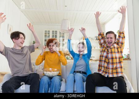 Eine Gruppe von Freunden, die sich ein Fußballspiel im fernsehen anschauen. Glückliche Fußballfans feiern zu Hause den Sieg. Freundschaft sp Stockfoto