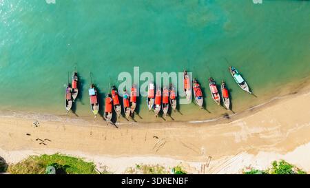 Farbenfrohe Langboot-Boote säumen das Ufer des Railay Beach in Krabi, Thailand, unter hellem Himmel Stockfoto