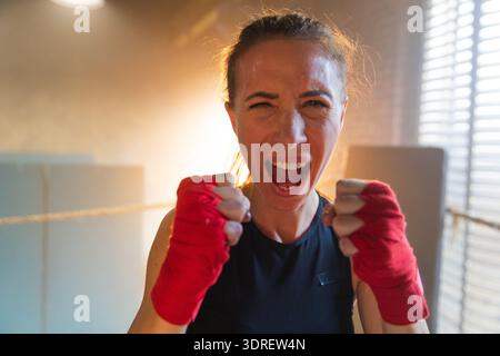 Aufschrei unabhängiger Mädels Macht. Wütende, starke, verrückte Kämpferin, die aggressiv auf Boxring aussieht. Kraftvoll und ehrgeizig Stockfoto