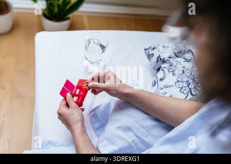 Nahaufnahme reife Weiße Frau mittleren Alters organisiert Ergänzungen zu Hause Stockfoto