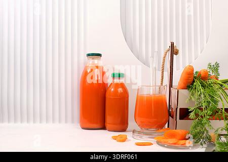 Frischer natürlicher Karottensaft oder Smoothie, Detox Drink in Glasflasche und Glas, frische Karotte in Box auf Küchenhintergrund, hilft wei Stockfoto