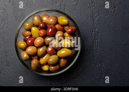 Eine Auswahl verschiedener Oliven in einer Schüssel mit verschiedenen Farben, Texturen und Aromen Stockfoto
