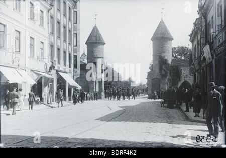 Dieses Foto zeigt die Viru-Straße in Tallinn, Estland, mit Blick auf die vorderen Tortürme des Viru-Tores, aufgenommen zwischen 1930 und 1940. Das Bild zeigt mittelalterliche Verteidigungstürme, Mauern, Straßenaufteilung und umliegende Gebäude. Das Viru-Tor war Teil der Stadtbefestigung Tallinns. Das Foto bewahrt architektonische Details, Straßenlandschaft und urbanes Erbe und dokumentiert die mittelalterlichen Verteidigungsbauten und die städtische Umgebung von Tallinns historischer Altstadt während der Zwischenkriegszeit. Stockfoto