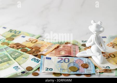 Die Euro-Banknoten und -Münzen liegen auf einem Marmortisch. Geld anziehendes Konzept Stockfoto