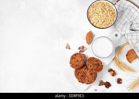 Frisch gebackene hausgemachte Haferflockenkekse mit Schokoladenchips und glutenfreien Nüssen mit Ohren auf Betonhintergrund, moderne Bäckerei Stockfoto