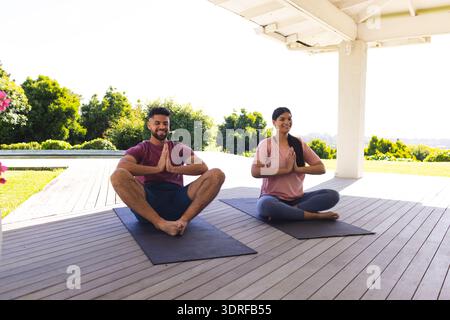 Paare üben Yoga auf Matten im Freien und genießen friedliche Morgenmeditation Stockfoto