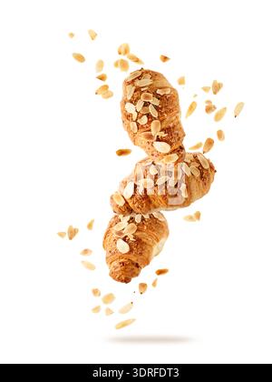 Frisch gebackene Mandel Frühstück Croissants mit Nusskrümeln fliegen isoliert auf weißem Hintergrund. Drei Croissants fallen. Konditorei Karte. Stockfoto