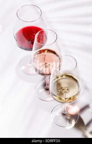 Drei Weingläser gefüllt mit Rot-, weiß- und Rosenwein Stockfoto