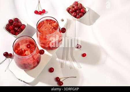 Kalter hausgemachter Limonade-Cocktail, Mojito mit Minze, Kirsche und Stachelbeere auf einem sonnigen Tisch, erfrischendes Sommergetränk Rezept, Entgiftung Stockfoto