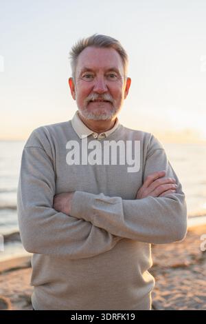 Porträt eines selbstbewussten, stilvollen europäischen Seniorenmannes mittleren Alters zu Hause. Älterer reifer Mann der 70er Jahre lächelt. Glückliche attraktive Seniorengra Stockfoto