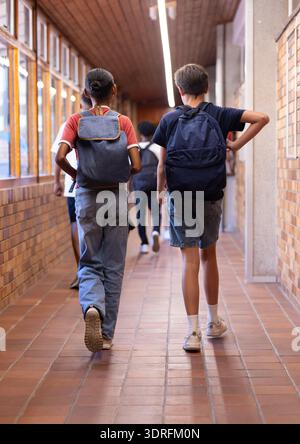Im Schulflur laufen, Schüler mit Rucksäcken auf dem Weg zur Klasse Stockfoto