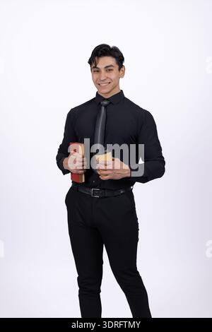 Mann in schwarzem Hemd, der eine Tasse Kaffee hält Stockfoto