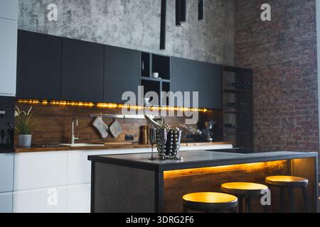 Leere skandinavische klassische, minimalistische dunkelgraue Küche mit Holzdetails. Stilvolles Loft, moderne schwarz-graue weiße Küche Deko Stockfoto