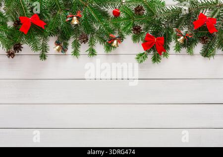 Collage von Weihnachtsdekorationen mit Kiefernzweigen, Glocken und Bögen auf hölzernem Hintergrund Stockfoto