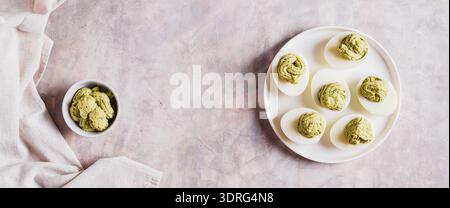 Avocadoeier als Vorspeise auf dem Teller auf dem Web-Banner mit Blick auf den Tisch Stockfoto