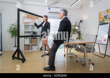Der Chef und der Assistent sind auf einer Mission, den Fortschritt eines Geschäftsprojekts zu überwachen Stockfoto