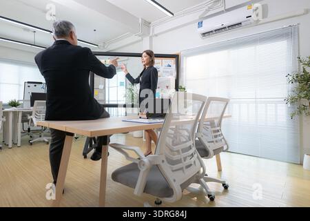 Der Chef und der Assistent sind auf einer Mission, den Fortschritt eines Geschäftsprojekts zu überwachen Stockfoto