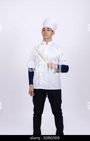 Porträt eines jungen Küchenchefs mit weißem Mantel und Hut Stockfoto