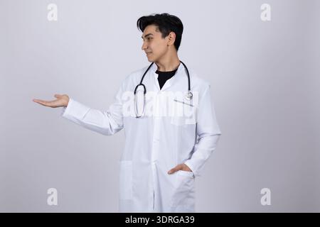 Männlicher Arzt im weißen Mantel, der den Kopierraum präsentiert Stockfoto