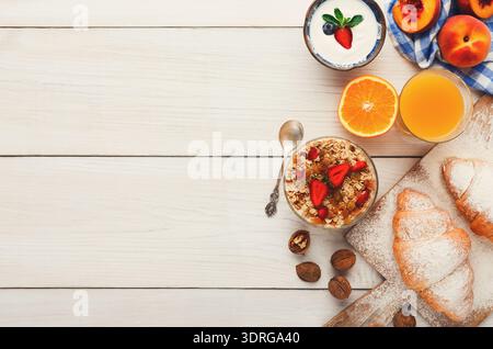 Frühstückssammlung auf einem Holztisch mit Obst, Joghurt und Gebäck Stockfoto