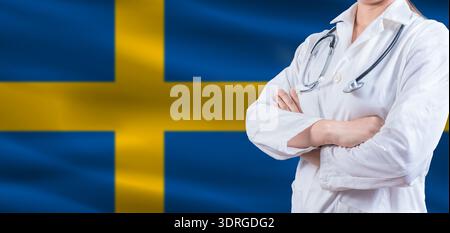 Doktor mit gekreuzten Armen auf schwedischer Flagge. Schwedisches Gesundheits- und Pflegekonzept. Ärztin auf schwedischer Flagge Stockfoto