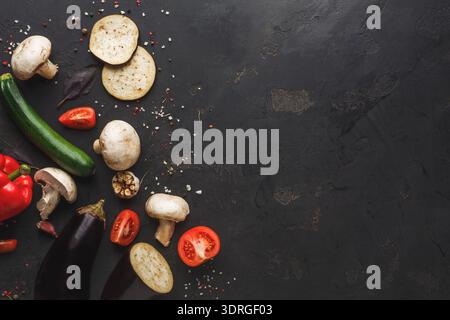Sammlung von frischem Gemüse auf dunkler Oberfläche für eine Sitzung zur Zubereitung von Rezepten Stockfoto