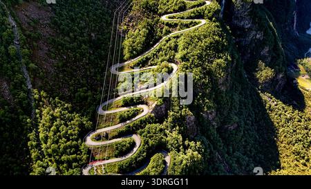 Eine gewundene Bergstraße durch üppiges Grün in Norways atemberaubender Landschaft Stockfoto