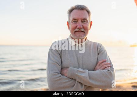 Porträt eines selbstbewussten, stilvollen europäischen Seniorenmannes mittleren Alters zu Hause. Älterer reifer Mann der 70er Jahre lächelt. Glückliche attraktive Seniorengra Stockfoto
