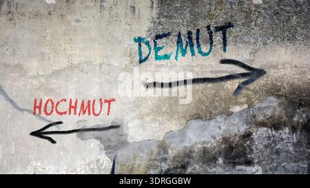 Ein Bild mit einem Wegweiser, der in zwei verschiedene Richtungen auf Deutsch zeigt. Eine Richtung weist auf Demut hin, die andere auf eine Stockfoto