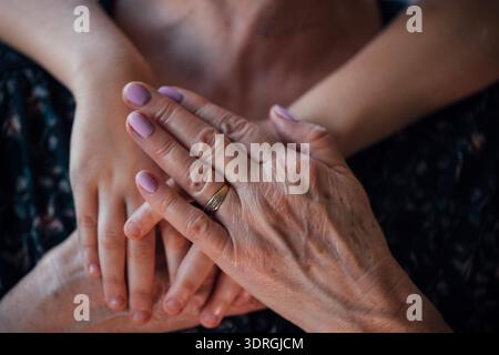 Nahaufnahme einer Reifen Frau, die Hände eines kleinen Kindes hält Stockfoto