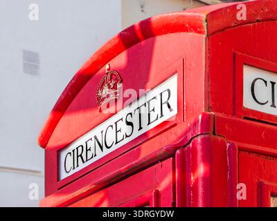 Schließen Sie das obere Detail einer traditionellen roten britischen Telefonbox in Cirencester mit einem königlichen Kronemblem und Cirencester-Text Stockfoto
