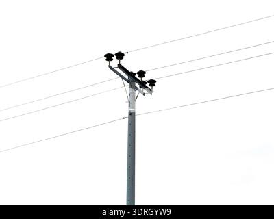 Stromleitungsposten mit Keramikisolierungen und Kabeln vor bewölktem Himmel, geringer Blickwinkel. Stromübertragungsnetz Stockfoto