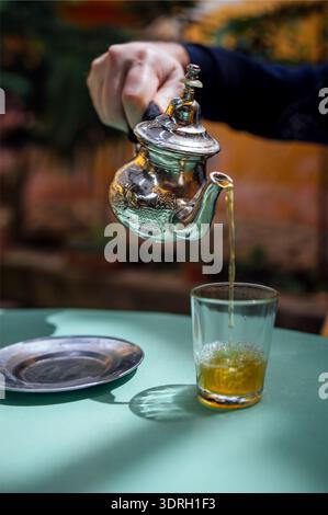 Silberner orientalischer Teekanne und Teetasse, um traditionellen marokkanischen Tee im lokalen Riad zu trinken Stockfoto