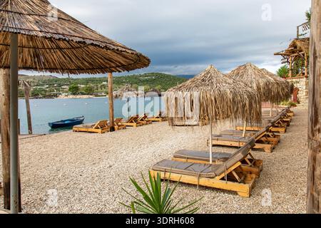 Strohschirme an einem leeren Strand nach der Tourismussaison im Ferienort Ksamil, Albanien Stockfoto