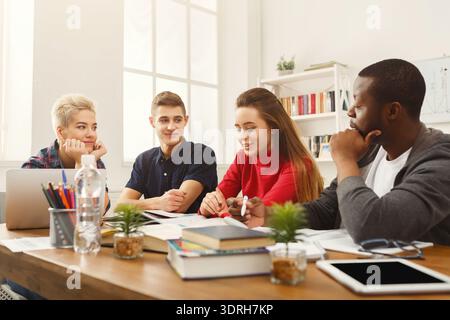 Gruppe von Studenten, die in einer Lernsitzung mit Büchern und Laptops zusammenarbeiten Stockfoto