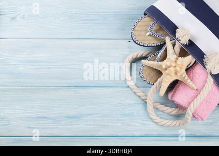Strand-Accessoires. Tasche, Handtuch und Badelatschen auf hölzernen Hintergrund. Draufsicht mit Textfreiraum Stockfoto