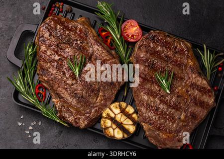 Gegrillte Ribeye-Steaks auf schwarzem Hintergrund, Blick von oben Stockfoto