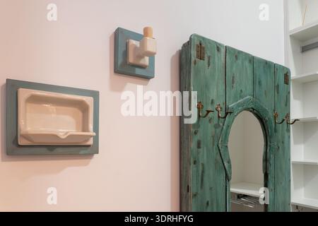 Seifenhalter und Haken aus Vintage-Keramik, mit rustikalem Holzspiegel mit Messinghaken, die dekorative Elemente zu einer einfachen Wand hinzufügen Stockfoto