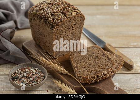 Frisch gebackenes hausgemachtes Mehrkorn-Sauerteigbrot, Holzhintergrund, Kopierraum Stockfoto