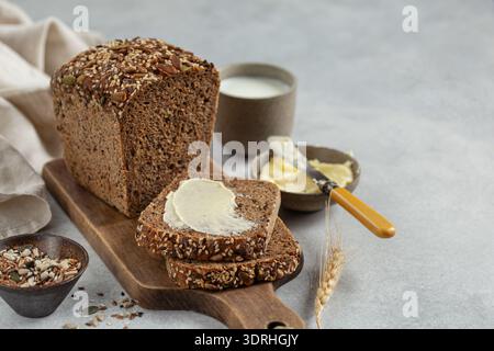 Scheiben frisch gebackenes, hausgemachtes, mehrkörniges Roggenbrot mit Butter Stockfoto