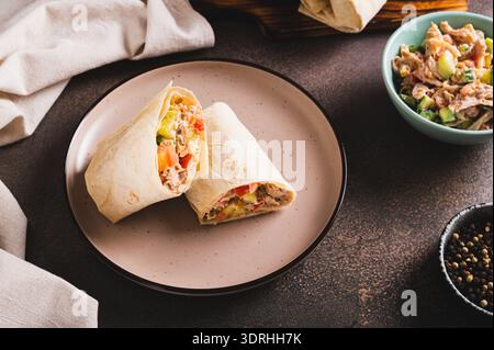Shawarma in Pitabrot mit Fleisch und Gemüse auf einem Teller auf dem Tisch Stockfoto