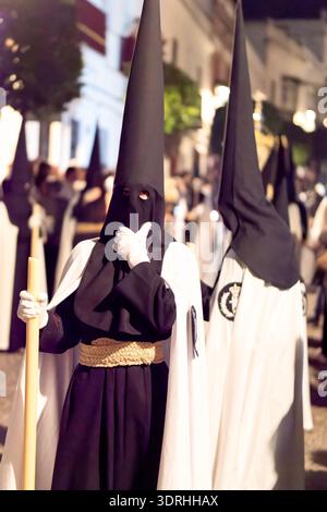 Blick auf die Bußen in traditionellen Hauben und Bademänteln während einer Nachtprozession Stockfoto