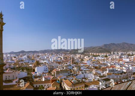 Malaga, Spanien. Blick auf die Dächer der Innenstadt und die fernen Berge. Mediterrane Stadtlandschaft mit historischen Kirchtürmen und trad Stockfoto