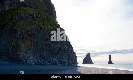 Erkunden Sie den atemberaubenden Reynisfjara Beach mit einzigartigem schwarzem Sand, hoch aufragenden Basaltsäulen und majestätischen Meeresstapeln in Island Stockfoto